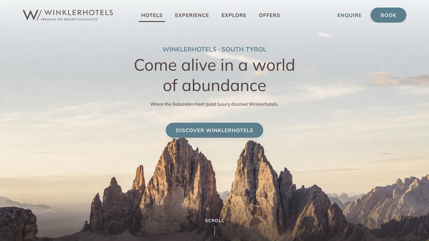 Hero variant B, Brand Story First: a full-bleed Dolomites photograph, the headline 'Come alive in a world of abundance' and a single soft call to action, 'Discover Winklerhotels'